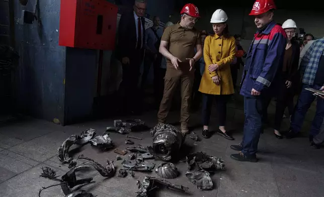 German's Foreign Minister Annalena Baerbock and Ukrainian Energy Minister Herman Halushchenko look on fragments of Russian rocket during official visit to a thermal power plant which was destroyed by a Russian rocket attack in Ukraine, Tuesday, May 21, 2024. (AP Photo/Evgeniy Maloletka)