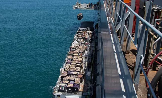 Humanitarian aid is lifted by a crane operated by soldiers assigned to the 7th Transportation Brigade (Expeditionary) from a Navy causeway at the Port of Ashdod, Israel, May 14, 2024. These soldiers are supporting the construction of the Joint Logistics Over-the-Shore system off the shore of Gaza. (Staff Sgt. Malcolm Cohens-Ashley/U.S. Army via AP)