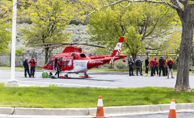 Emergency crews gather near Intermountain Life Flight at Hidden Valley Park in Sandy, Utah, after responding to a report of an avalanche and three missing skiers in Little Cottonwood Canyon on Thursday, May 9, 2024. (Isaac Hale/The Deseret News via AP)