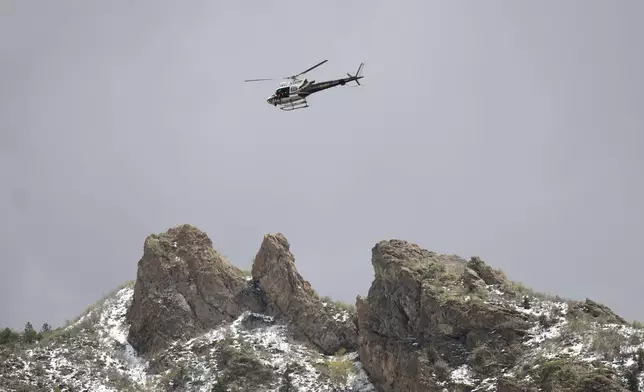 A Utah Department of Public Safety helicopter carries rescuers from Hidden Valley Park, Thursday, May 9, 2024 Thursday, May 9, 2024, in Sandy, Utah. One skier was rescued and two remained missing following an avalanche in the mountains outside of Salt Lake City. The slide happened after several days of spring snowstorms. (AP Photo/Rick Bowmer)