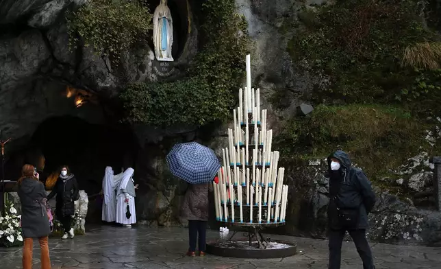 Pilgrims pray at the Roman Catholic shrine in Lourdes, southwestern France, Friday, Feb.11, 2022. On Friday, May 17, 2024, the Vatican will issue revised norms for discerning apparitions "and other supernatural phenomena," updating a set of guidelines first issued in 1978. (AP Photo/Bob Edme, File)