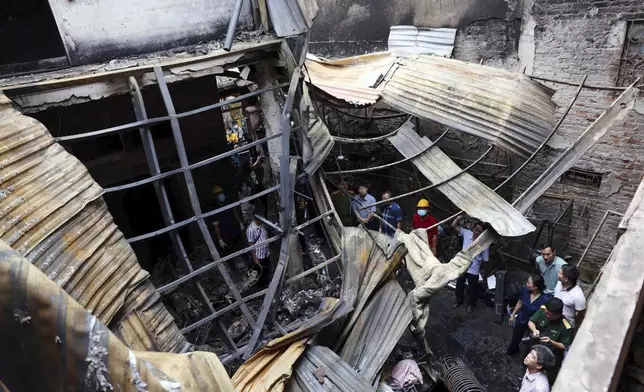 Officials visit the site of a house fire in Hanoi, Vietnam Friday, May 24, 2024. Authorities said the fire has killed a number of people and injured a few others. (An Van Dang/VNA via AP)
