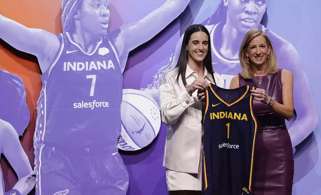 FILE - Iowa's Caitlin Clark, left, poses for a photo with WNBA commissioner Cathy Engelbert, right, after being selected first overall by the Indiana Fever during the first round of the WNBA basketball draft, April 15, 2024, in New York. The wait for full-time charter flights for WNBA teams finally is over with commissioner Engelbert announcing Tuesday, May 7, the league's plans to start the program this season. (AP Photo/Adam Hunger, File)