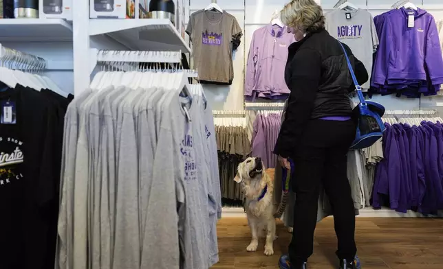 A woman shops with her dog during the 148th Westminster Kennel Club Dog show, Saturday, May 11, 2024, at the USTA Billie Jean King National Tennis Center in New York. (AP Photo/Julia Nikhinson)