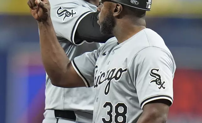 Chicago White Sox's Eloy Jimenez celebrates with first base coach/outfield coach Jason Bourgeois (38) after hitting a single off Tampa Bay Rays starting pitcher Aaron Civale during the fourth inning of a baseball game Wednesday, May 8, 2024, in St. Petersburg, Fla. (AP Photo/Chris O'Meara)