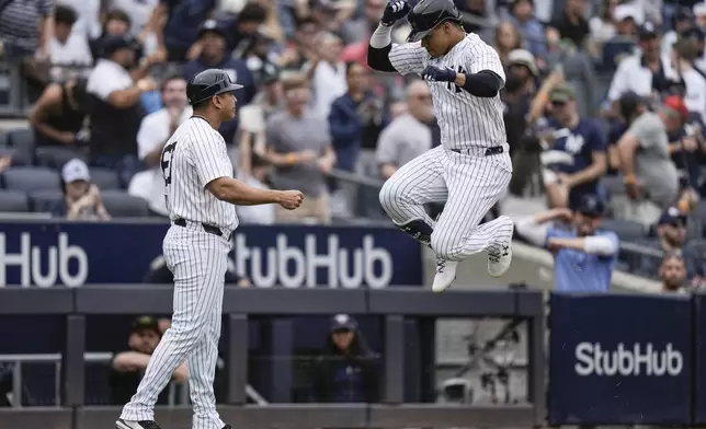 New York Yankees' Juan Soto, right, celebrates with third base coach Luis Rojas as he runs the bases after hitting a home run during the fifth inning of a baseball game against the Chicago White Sox, Saturday, May 18, 2024, in New York. (AP Photo/Frank Franklin II)