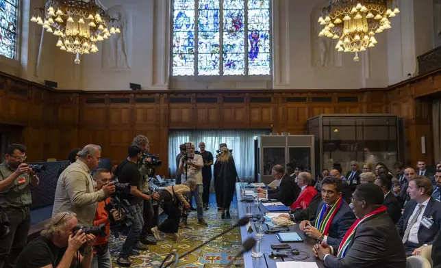 Members of the media take images of South Africa's delegation, front right, at the International Court of Justice, in The Hague, Netherlands, Thursday, May 16, 2024. The U.N.'s top court opened two days of hearings in a case brought by South Africa to see whether Israel needs to take additional measures to alleviate the suffering in war-ravaged Gaza. (AP Photo/Peter Dejong)