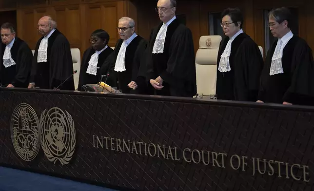 Presiding judge Nawaf Salam, fourth from left, arrives to read the ruling at the International Court of Justice in The Hague, Netherlands, Tuesday, April 30, 2024. The top U.N. court rejected on Tuesday a request by Nicaragua to order Germany to halt military and other aid to Israel and renew funding to the U.N. aid agency in Gaza. The International Court of Justice said that legal conditions for making such an order weren't met and ruled against the request in a 15-1 vote. (AP Photo/Peter Dejong)
