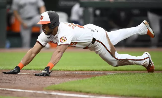 Baltimore Orioles' Anthony Santander slides towards home to score during the second inning of a baseball game against the New York Yankees, Tuesday, April 30, 2024, in Baltimore. Santander scored from second base on a fielders choice by Orioles' Jordan Westburg and a throwing error by Yankees second baseman Gleyber Torres.(AP Photo/Nick Wass)