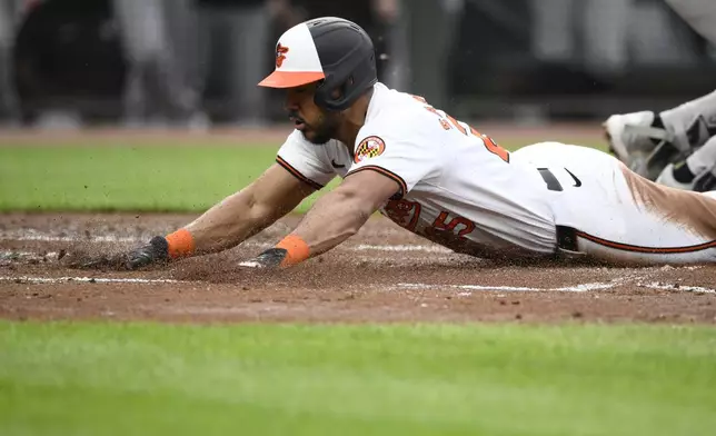 Baltimore Orioles' Anthony Santander slides home to score during the second inning of a baseball game against the New York Yankees, Tuesday, April 30, 2024, in Baltimore. Santander scored from second base on a fielders choice by Orioles' Jordan Westburg and a throwing error by Yankees second baseman Gleyber Torres. (AP Photo/Nick Wass)
