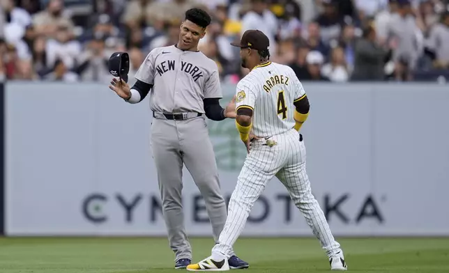 New York Yankees right fielder Juan Soto, left, jokes with San Diego Padres first baseman Luis Arraez before a baseball game, Saturday, May 25, 2024, in San Diego. (AP Photo/Gregory Bull)