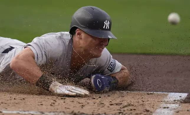 New York Yankees' Anthony Volpe slides into home, scoring from third base on a sacrifice fly by Aaron Judge during the first inning of a baseball game against the San Diego Padres, Friday, May 24, 2024, in San Diego. (AP Photo/Gregory Bull)