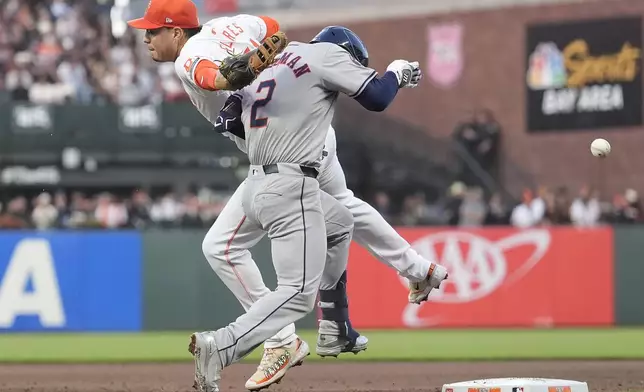 Houston Astros' Alex Bregman (2) runs to first base on an RBI single as San Francisco Giants first baseman Wilmer Flores, left, cannot catch a throw by third baseman Matt Chapman, who was charged with an error, which allowed a second run to score during the fifth inning of a baseball game in San Francisco, Tuesday, June 11, 2024. (AP Photo/Jeff Chiu)