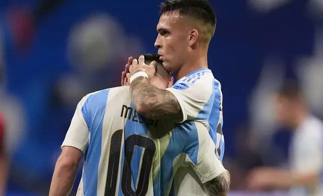 Argentina's Lautaro Martinez, right, embraces teammate Lionel Messi at the end of a Copa America Group A soccer match against Canada in Atlanta, Thursday, June 20, 2024. (AP Photo/Mike Stewart)