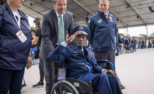 U.S. World War II veteran and Tuskegee Airman, Enoch "Woody" Woodhouse salutes as he arrives to an international ceremony to mark the 80th anniversary of D-Day at Omaha Beach in Saint-Laurent-sur-Mer, Normandy, France, Thursday, June 6, 2024. World leaders are gathered Thursday in France to mark the 80th anniversary of the D-Day landings. (AP Photo/Virginia Mayo)