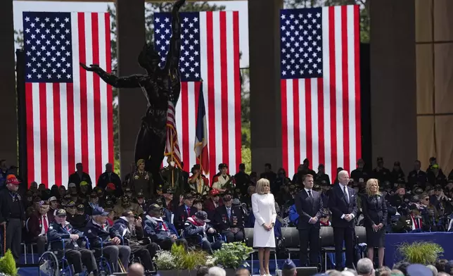 French President Emmanuel Macron, 2nd left, his wife Brigitte Macron, left, and US President Joe Biden, center right, and first lady Jill Biden attend a ceremony together with World War II veterans at an US cemetery near Colleville-sur-Mer Normandy, Thursday, June 6, 2024. World War II veterans from across the United States as well as Britain and Canada are in Normandy this week to mark 80 years since the D-Day landings that helped lead to Hitler's defeat. (AP Photo/Laurent Cipriani)