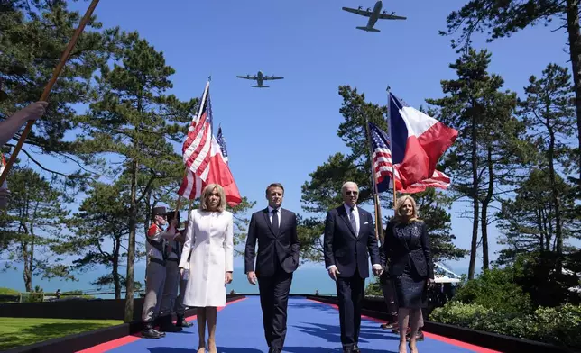 President Joe Biden, first lady Jill Biden, French President Emmanuel Macron, his wife Brigitte Macron, walk on stage during ceremonies to mark the 80th anniversary of D-Day, Thursday, June 6, 2024, in Normandy. (AP Photo/Evan Vucci)