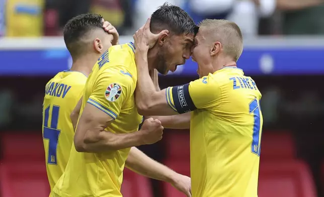 Ukraine's Roman Yaremchuk, center, celebrates after scoring his side's second goal during a Group E match between Slovakia and Ukraine at the Euro 2024 soccer tournament in Duesseldorf, Germany, Friday, June 21, 2024. (Rolf Vennenbernd/dpa via AP)
