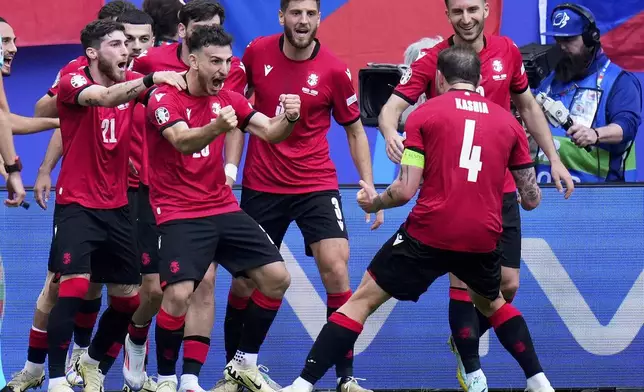 Georgia players celebrate after Georges Mikautadze scored the opening goal from the penalty spot during a Group F match between Georgia and the Czech Republic at the Euro 2024 soccer tournament in Hamburg, Germany, Saturday, June 22, 2024. (AP Photo/Petr David Josek)