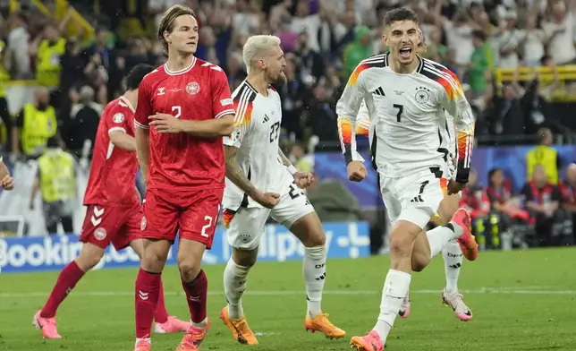 Germany's Kai Havertz celebrates after scoring his side's opening goal from a penalty kick next to Denmark's Joachim Andersen during a round of sixteen match between Germany and Denmark at the Euro 2024 soccer tournament in Dortmund, Germany, Saturday, June 29, 2024. (AP Photo/Andreea Alexandru)