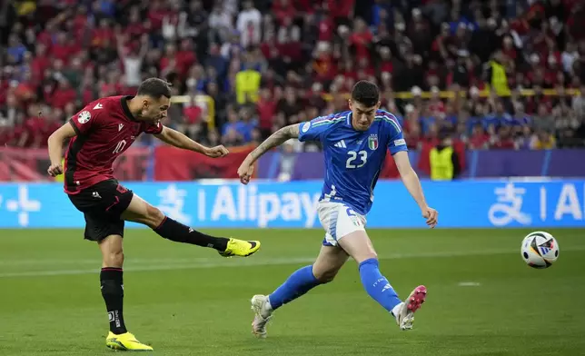 Albania's Nedim Bajrami, left, scores his side's opening goal in front of Italy's Alessandro Bastoni during a Group B match between Italy and Albania at the Euro 2024 soccer tournament in Dortmund, Germany, Saturday, June 15, 2024. (AP Photo/Alessandra Tarantino)