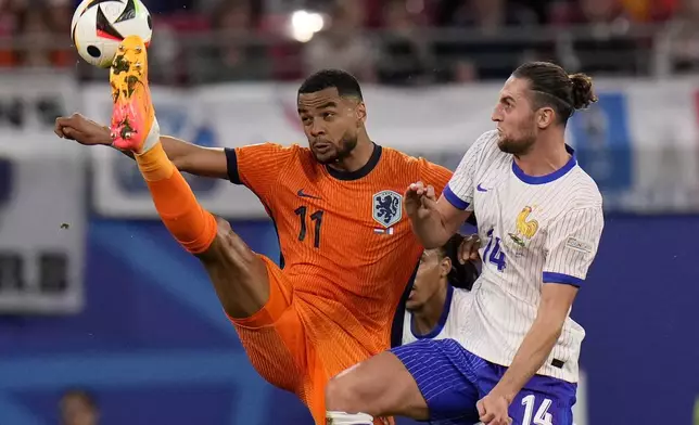 Cody Gakpo of the Netherlands, left, is challenged by Adrien Rabiot of France during the Group D match between the Netherlands and France at the Euro 2024 soccer tournament in Leipzig, Germany, Friday, June 21, 2024. (AP Photo/Hassan Ammar)