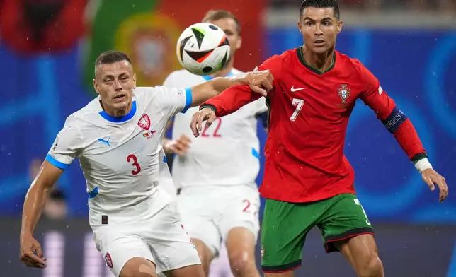 Portugal's Cristiano Ronaldo, right, duels for the ball with Czech Republic's Tomas Holes during a Group F match between Portugal and Czech Republic at the Euro 2024 soccer tournament in Leipzig, Germany, Tuesday, June 18, 2024. (AP Photo/Petr Josek)