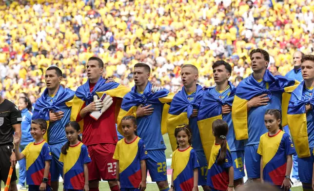 Ukrainian players sing their national anthem prior to a Group E match between Romania and Ukraine at the Euro 2024 soccer tournament in Munich, Germany, Monday, June 17, 2024. (AP Photo/Antonio Calanni)