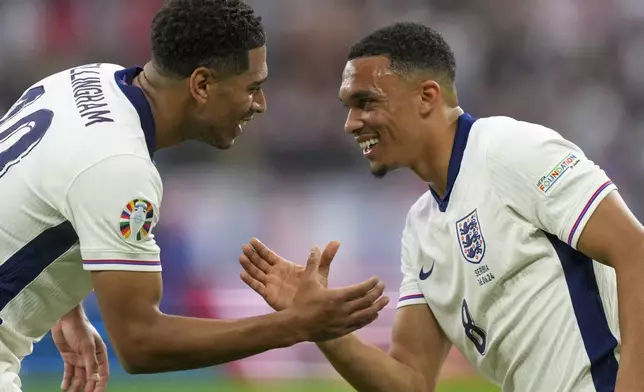 England's Jude Bellingham, left, celebrates with England's Trent Alexander-Arnold after scoring the opening goal during a Group C match between Serbia and England at the Euro 2024 soccer tournament in Gelsenkirchen, Germany, Sunday, June 16, 2024. (AP Photo/Martin Meissner)