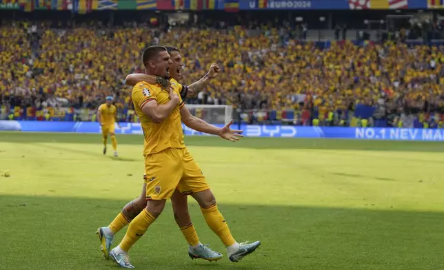 Romania's Razvan Marin, front, celebrates after scoring his side's first goal against Slovakia during a Group E match at the Euro 2024 soccer tournament in Frankfurt, Germany, Wednesday, June 26, 2024. (AP Photo/Themba Hadebe)