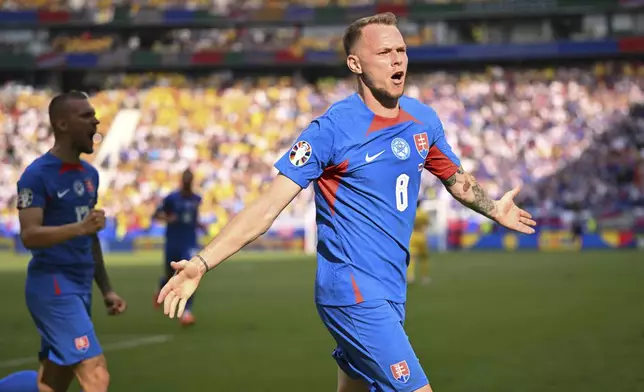 Slovakia's Ondrej Duda, right, celebrates after scoring the opening goal against Romania during a Group E match at the Euro 2024 soccer tournament in Frankfurt, Germany, Wednesday, June 26, 2024. (Arne Dedert/dpa via AP)