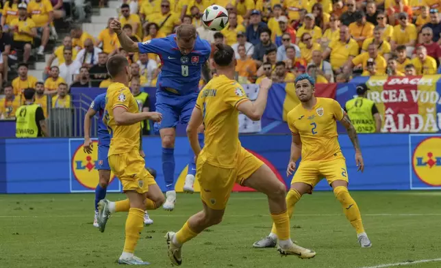 Slovakia's Ondrej Duda, second left, scores the opening goal during a Group E match between Slovakia and Romania at the Euro 2024 soccer tournament in Frankfurt, Germany, Wednesday, June 26, 2024. (AP Photo/Frank Augstein)