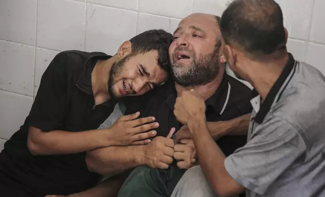 The father of Mohammad al-Habil weeps with his relatives after his son was killed with his uncle, Abdul Muti al-Habil, while they were fishing in the sea when Israeli gunboats opened fire on them in Deir al Balah, Gaza Strip, Friday, June 14, 2024. The bodies of the two fishermen were brought to Al-Aqsa Martyrs Hospital after they were shot by Israel's navy, the hospital officials said. (AP Photo/Mohammad Hajjar)