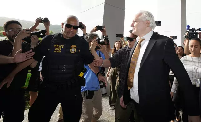 WikiLeaks founder Julian Assange, right, arrives, surrounded by the the media, at the United States courthouse where he is expected enter a plea deal, in Saipan, Mariana Islands, Wednesday, June 26 2024. (AP Photo/Eugene Hoshiko)