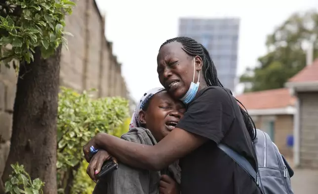 Edith Wanjiku, left, weeps after viewing the body of her son, who was allegedly shot by police during Tuesday's protest at the Nairobi funeral home, Kenya Wednesday, June 26, 2024. Thousands of protesters stormed and burned a section of Kenya's parliament Tuesday to protest tax proposals. Police responded with gunfire and several protesters were killed. (AP Photo/Brian Inganga)