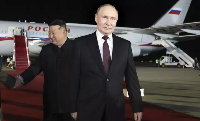 Russian President Vladimir Putin, right, walks as North Korea's leader Kim Jong Un shakes hands with the Russian delegation during their meeting at the Pyongyang Sunan International Airport outside Pyongyang, North Korea, early Wednesday, June 19, 2024. (Gavriil Grigorov, Sputnik, Kremlin Pool Photo via AP)