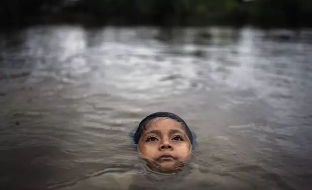 Maijuna youth Segundo Jeinsen bathes in a stream in Sucusari, Peru, Wednesday, May 29, 2024. A federal highway project in an untouched area of the Peruvian Amazon is facing mounting opposition from Indigenous tribes, including the Maijuna. (AP Photo/Rodrigo Abd)