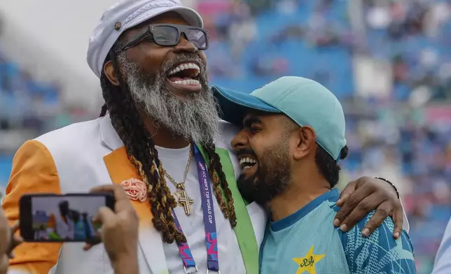 Pakistan's captain Babar Azam, right, shares a light moment with former West Indies' cricketer Chris Gayle before the start of the ICC Men's T20 World Cup cricket match between India and Pakistan at the Nassau County International Cricket Stadium in Westbury, New York, Sunday, June 9, 2024. (AP Photo/Stefan Jeremiah)