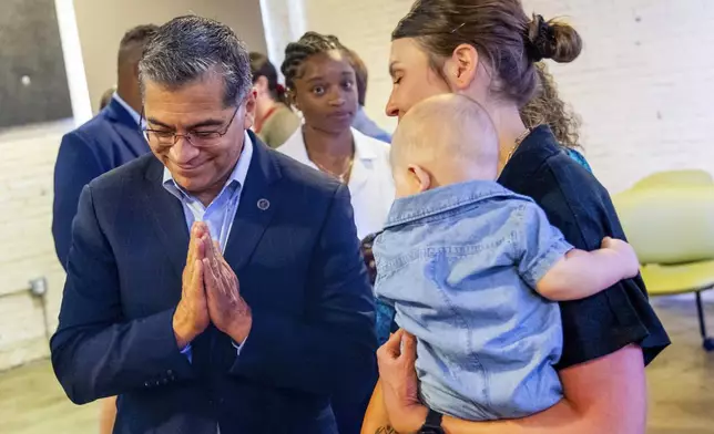 U.S. Health Secretary Xavier Becerra, left, thanks Jillaine St. Michel, holding 5-month-old Tucker, for participating after a conversation with local patients and providers who have been impacted by Idaho's abortion restrictions held at the Linen Building in Boise, Idaho, Wednesday, June 26, 2024. (AP Photo/Kyle Green)