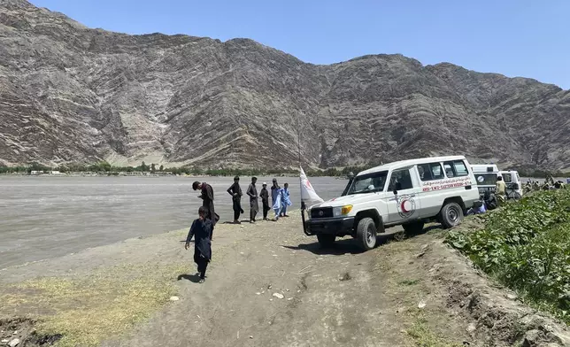 ARCS health workers vehicles are seen near to the site of sunken boat in Mohmand Dara district of Nangarhar province east of Kabul, Afghanistan, Saturday, June 1, 2024. At least 20 people were killed when a boat sank while crossing a river in eastern Afghanistan Saturday morning, a Taliban official said. (AP Photo)