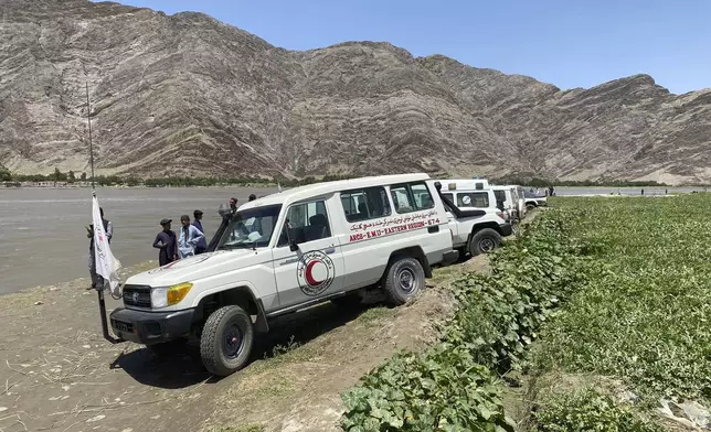 ARCS health workers vehicles are seen near to the site of sunken boat in Mohmand Dara district of Nangarhar province east of Kabul, Afghanistan, Saturday, June 1, 2024. At least 20 people were killed when a boat sank while crossing a river in eastern Afghanistan Saturday morning, a Taliban official said. (AP Photo)