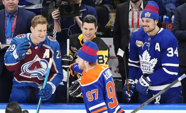 FILE - Edmonton Oilers' Connor McDavid is congratulated by Colorado Avalanche's Nathan MacKinnon, left to right, Pittsburgh Penguins' Sidney Crosby and Toronto Maple Leafs' Auston Matthews after winning the NHL All-Star hockey skills competition in Toronto, Friday, Feb. 2, 2024. Sidney Crosby, Connor McDavid and Nathan MacKinnon have never played together internationally for Canada. Same for Auston Matthews, Jack Eichel and Matthew Tkachuk with the U.S. That is finally set to change next year at the 4 Nations Face-Off, an international tournament precursor to the 2026 Milan Olympics that marks the return of NHL players to that world stage.(Frank Gunn/The Canadian Press via AP, File)