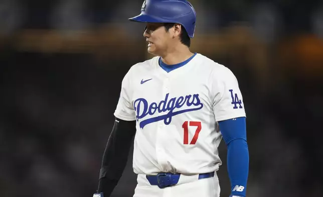 Los Angeles Dodgers designated hitter Shohei Ohtani stands on first during the eighth inning of a baseball game against the Los Angeles Angels in Los Angeles, Friday, June 21, 2024. (AP Photo/Ashley Landis)