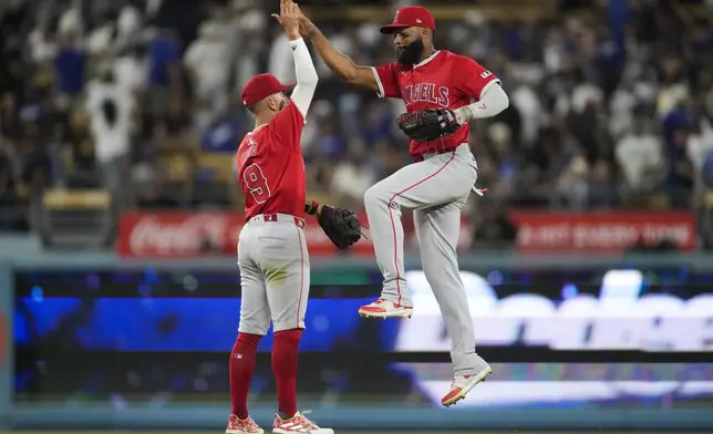 Los Angeles Angels shortstop Zach Neto (9) celebrates with right fielder Jo Adell after a 3-2 win over the Los Angeles Dodgers in a baseball game in Los Angeles, Friday, June 21, 2024. (AP Photo/Ashley Landis)