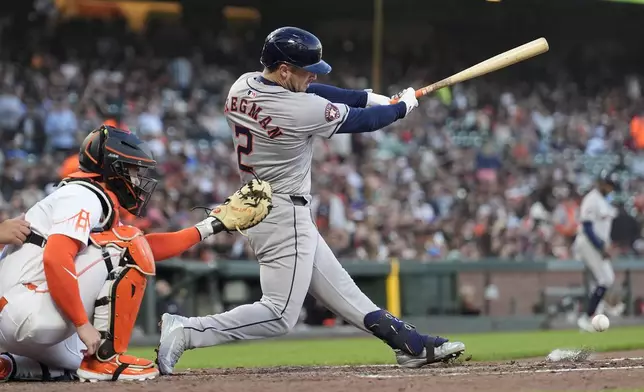 Houston Astros' Alex Bregman hits an RBI single in front of San Francisco Giants catcher Patrick Bailey during the fifth inning of a baseball game in San Francisco, Tuesday, June 11, 2024. Another run scored on a throwing error by third baseman Matt Chapman. (AP Photo/Jeff Chiu)