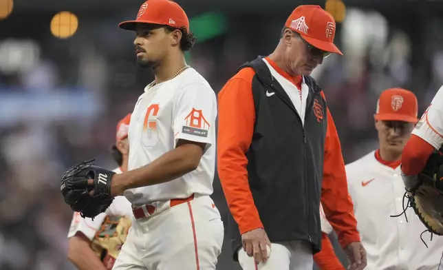 San Francisco Giants pitcher Jordan Hicks, left, walks off the mound after being taken out for a relief pitcher by manager Bob Melvin, right, during the fifth inning of the team's baseball game against the Houston Astros in San Francisco, Tuesday, June 11, 2024. (AP Photo/Jeff Chiu)