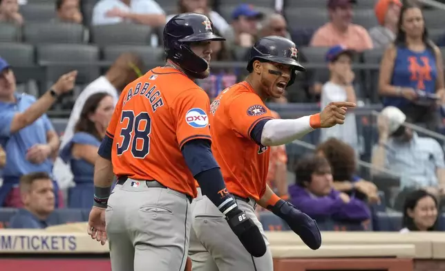 Houston Astros' Trey Cabbage, left, and Jeremy Peña celebrate after both scored on a single hit by Alex Bregman during the eighth inning of a baseball game against the New York Mets, Saturday, June 29, 2024, in New York. (AP Photo/Pamela Smith)