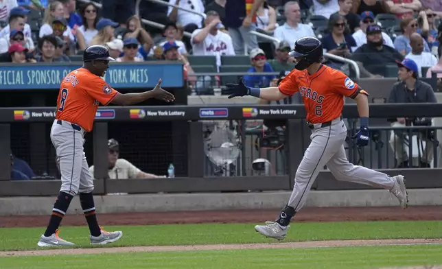 Houston Astros third base coach Gary Pettis, left, greets Jake Meyers as Meyers' heads home after hitting a home run in the second inning of a baseball game against the New York Mets, Saturday, June 29, 2024, in New York. (AP Photo/Pamela Smith)