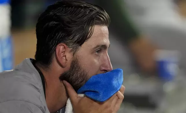 Oakland Athletics starting pitcher Mitch Spence sits in the dugout after being replaced T.J. McFarland during the sixth inning of the team's baseball game against the Los Angeles Angels, Tuesday, June 25, 2024, in Anaheim, Calif. (AP Photo/Ryan Sun)