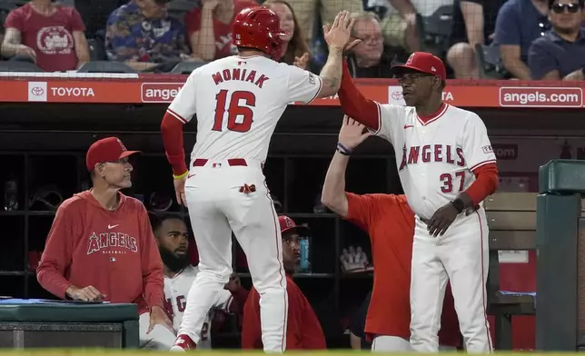 Los Angeles Angels' Mickey Moniak, left, celebrates with manager Ron Washington after scoring against the Oakland Athletics during the sixth inning of a baseball game Tuesday, June 25, 2024, in Anaheim, Calif. (AP Photo/Ryan Sun)